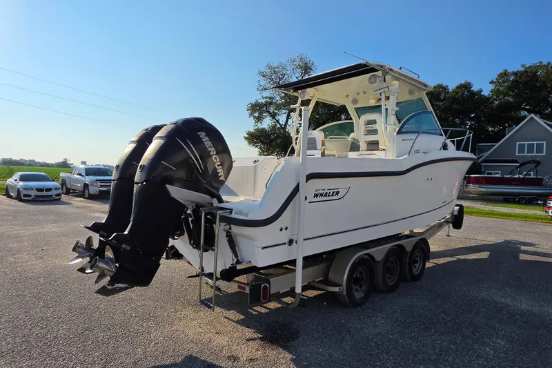 Slide: The Image of 2012 Boston Whaler 285 Conquest boat with dual Mercury engines on a trailer. - 7