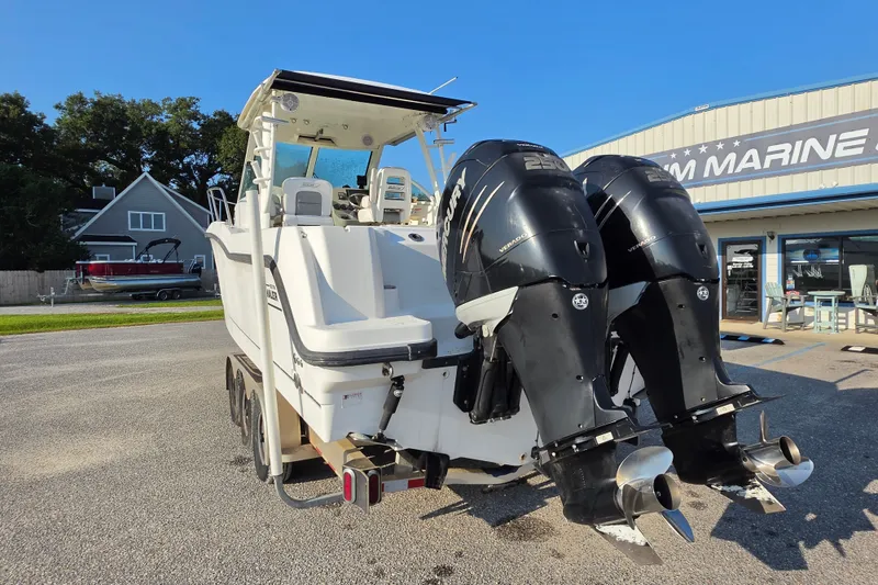Slide: The Image of 2012 Boston Whaler 285 Conquest boat with dual Mercury outboard engines at a marine dealership. - 8