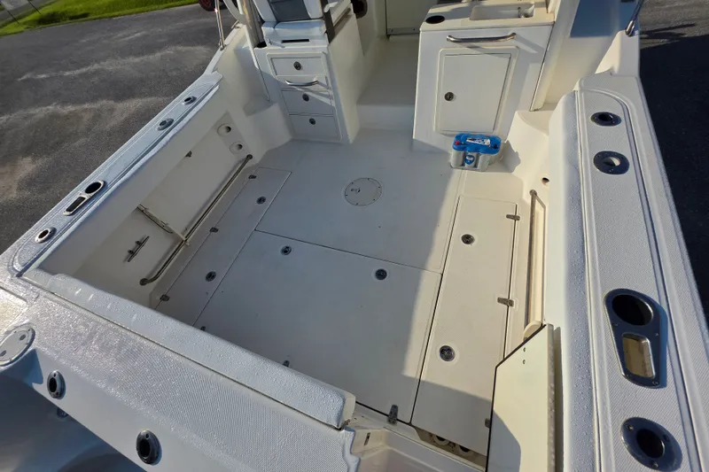 Slide: The Image of 2012 Boston Whaler 285 Conquest boat deck with storage compartments and rod holders. - 9
