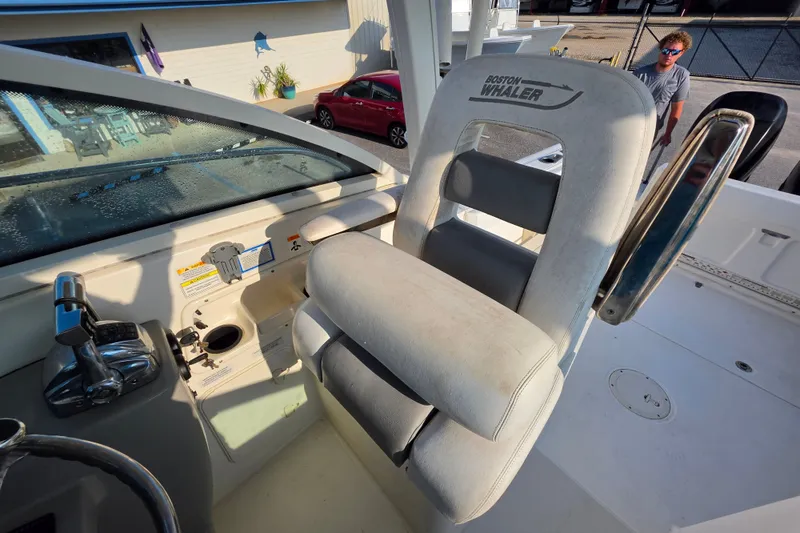 Slide: The Image of Helm seat of 2012 Boston Whaler 285 Conquest boat with controls and steering wheel. - 13
