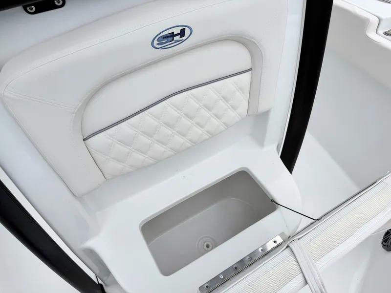 Slide: The Image of The image shows a white seat with a quilted pattern and a small storage compartment below. - 21