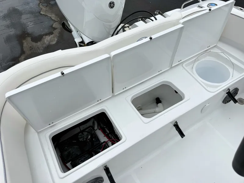 Slide: The Image of The image shows the storage compartments and battery of a Sea Hunt Ultra 219 boat. - 11