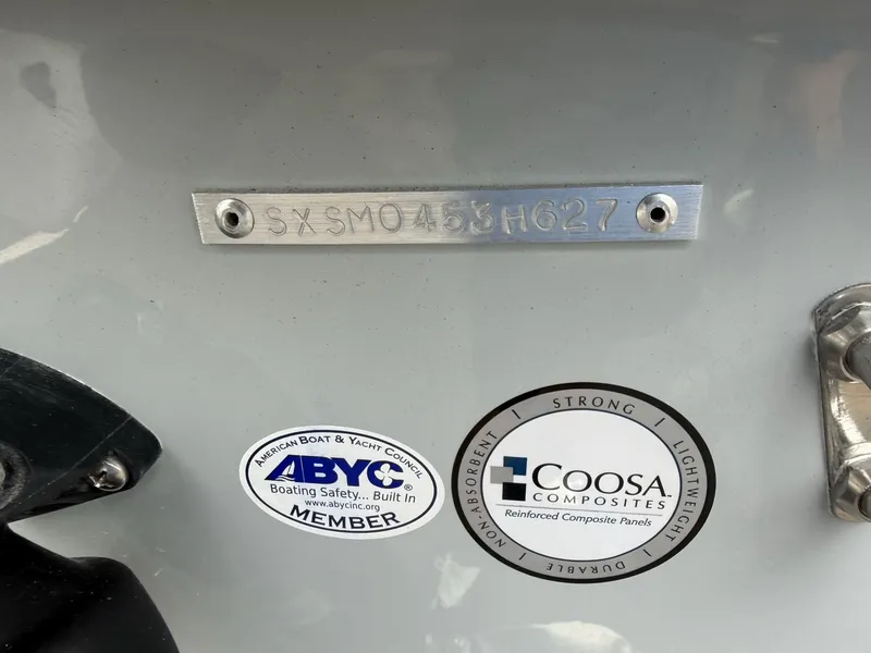 Slide: The Image of A boat with a serial number and stickers from ABYC and Coosa Composites. - 28