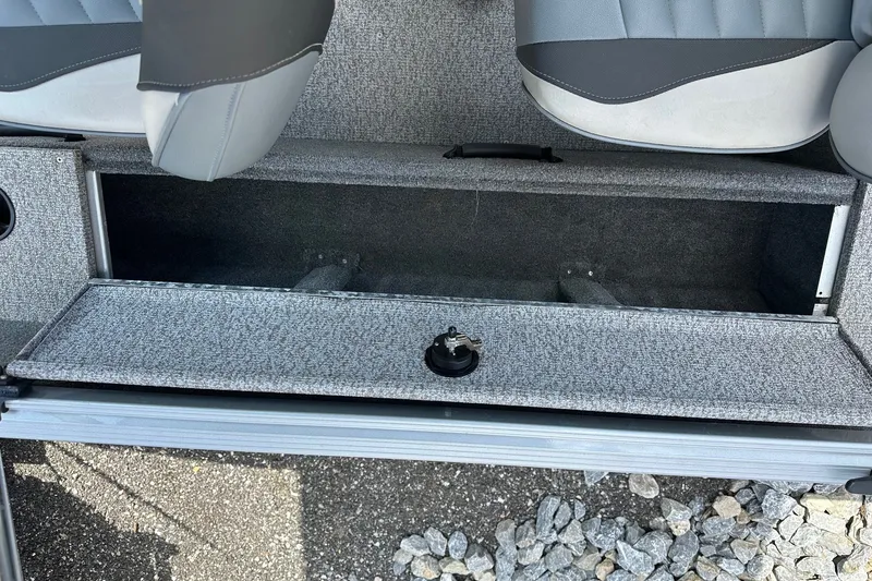 Slide: The Image of Storage compartment in a 2021 Alumacraft Classic 165 CS boat, featuring gray upholstery. - 15