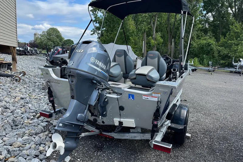 Slide: The Image of 2021 Alumacraft Classic 165 CS boat with Yamaha outboard motor, parked outdoors. - 22