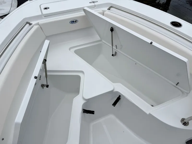 Slide: The Image of The image shows the bow area of a Sea Hunt Ultra 219 boat with open storage compartments. - 24
