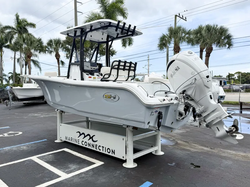 Slide: The Image of 2027 Sea Hunt Ultra 219 on a display stand, surrounded by palm trees. - 6