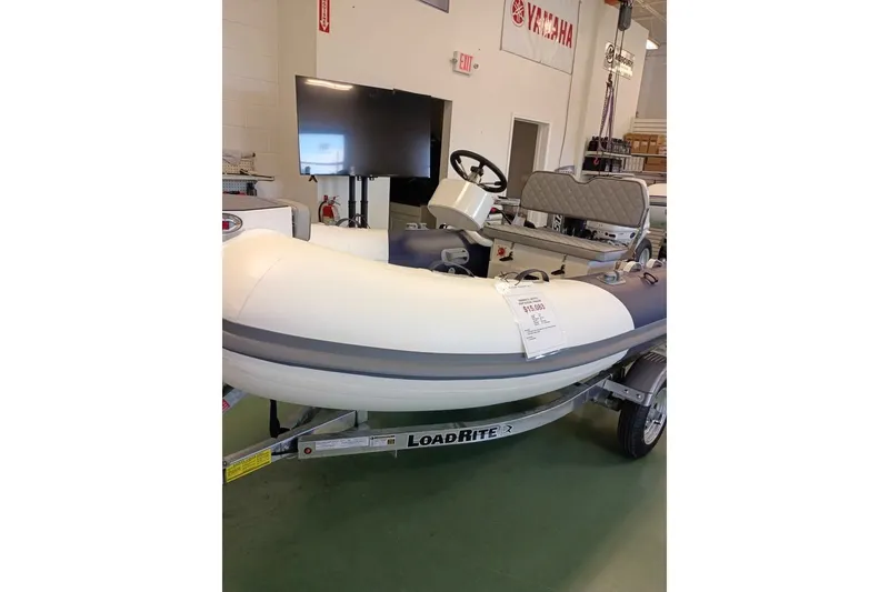 The Image of 2026 Desner CL 340 inflatable boat on Load Rite trailer in showroom. - 0