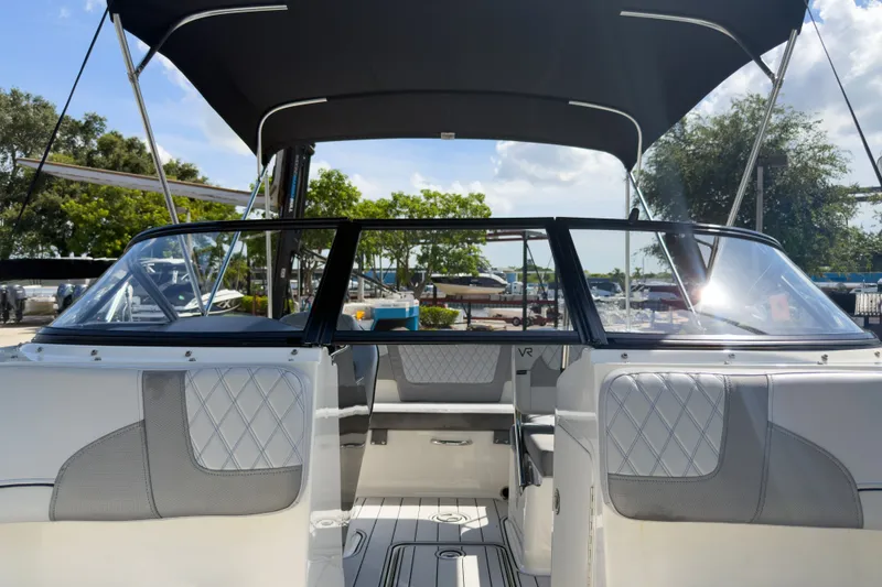 Slide: The Image of 2023 Bayliner VR5 Bowrider OB interior with seating and canopy under sunny skies. - 18
