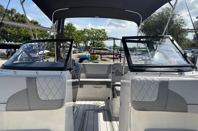 Slide: The Image of 2023 Bayliner VR5 Bowrider OB interior with seating and canopy under sunny skies. - 17