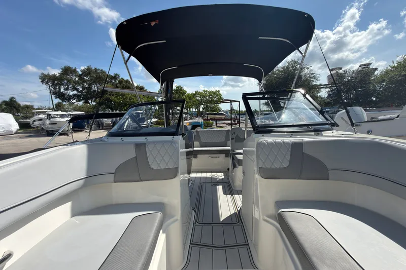 Slide: The Image of 2023 Bayliner VR5 Bowrider OB interior with seating and canopy under a sunny sky. - 16