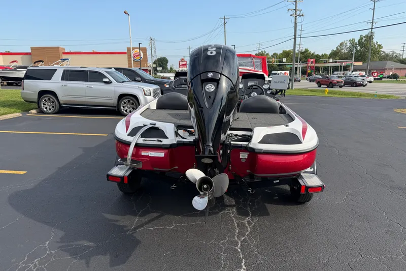Slide: The Image of Red 2016 Nitro Z18 boat with outboard motor in parking lot. - 2