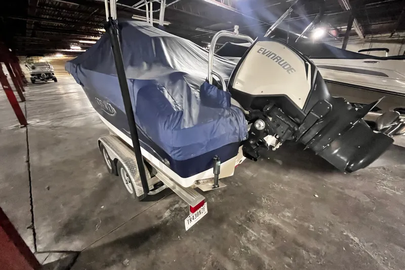Slide: The Image of 2020 Robalo R200 Center Console boat with Evinrude engine, covered and stored indoors. - 3