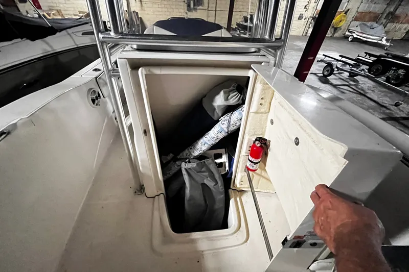 Slide: The Image of 2020 Robalo R200 Center Console storage compartment with fire extinguisher and gear. - 8