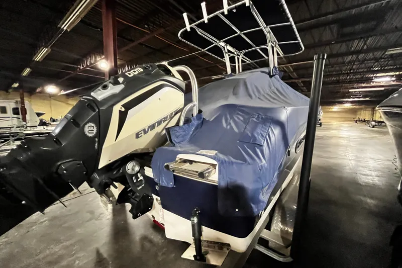 Slide: The Image of 2020 Robalo R200 Center Console boat with Evinrude engine, covered and stored indoors. - 4