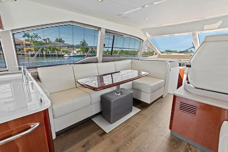 Slide: The Image of The image shows the interior of a 2018 Sea Ray Fly 460 with elegant seating and wood flooring. - 50