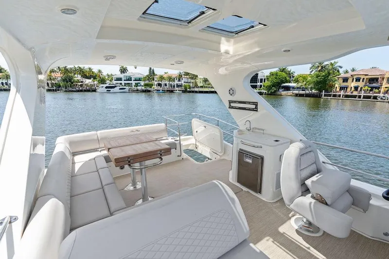 Slide: The Image of De afbeelding toont het ruime achterdek van een Sea Ray Fly 460 uit 2018 met zitplaatsen en een tafel. - 43