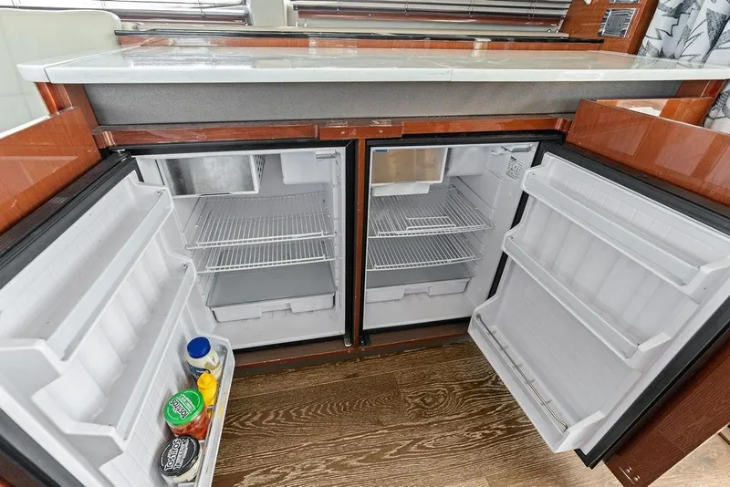 Slide: The Image of Die Küche der Sea Ray Fly 460 von 2018 zeigt zwei offene Kühlschränke mit leeren Regalen. - 48