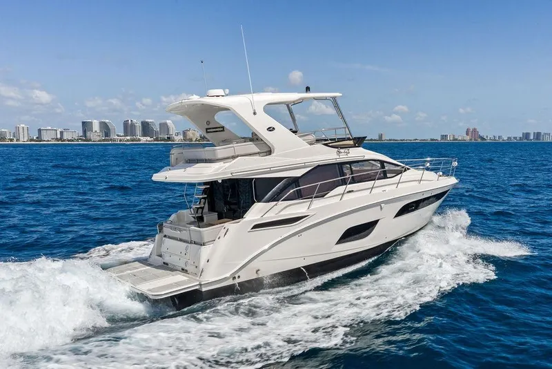 Slide: The Image of 2018 Sea Ray Fly 460 yacht cruising on blue ocean near city skyline. - 5