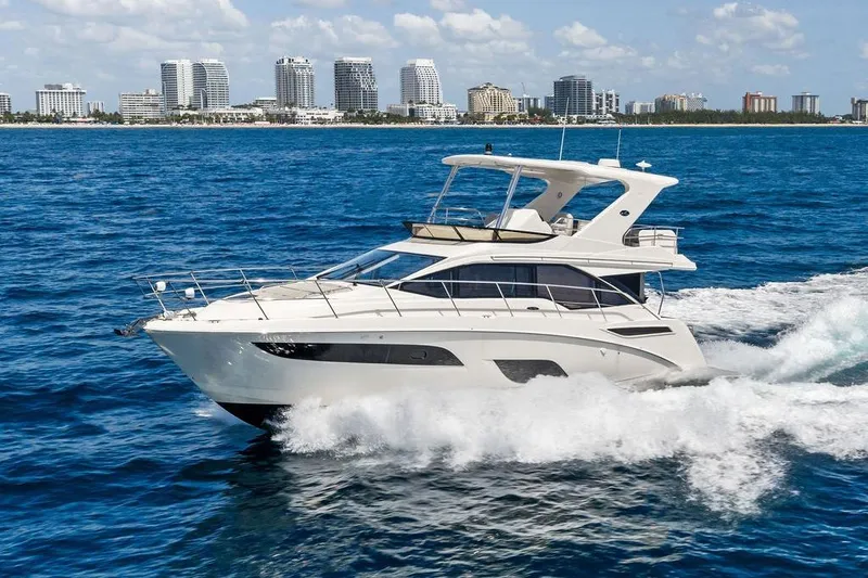 Slide: The Image of 2018 Sea Ray Fly 460 yacht cruising on blue ocean near city skyline. - 6