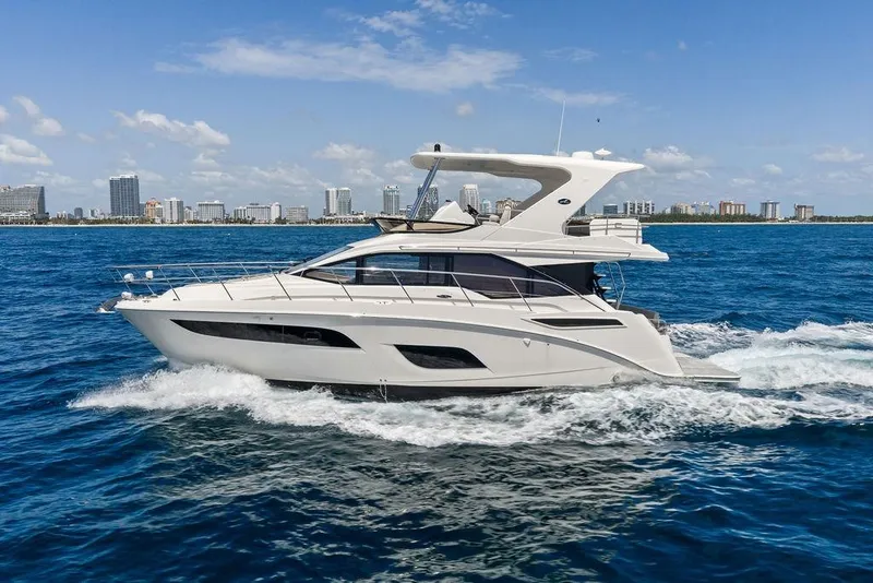 Slide: The Image of Een Sea Ray Fly 460 jacht uit 2018 vaart op zee met een stad op de achtergrond. - 8