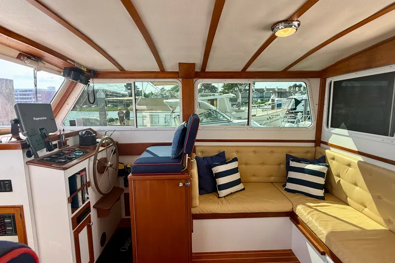 Slide: The Image of 1987 Wilbur Flybridge Cruiser interior with helm, seating, and nautical decor. - 41