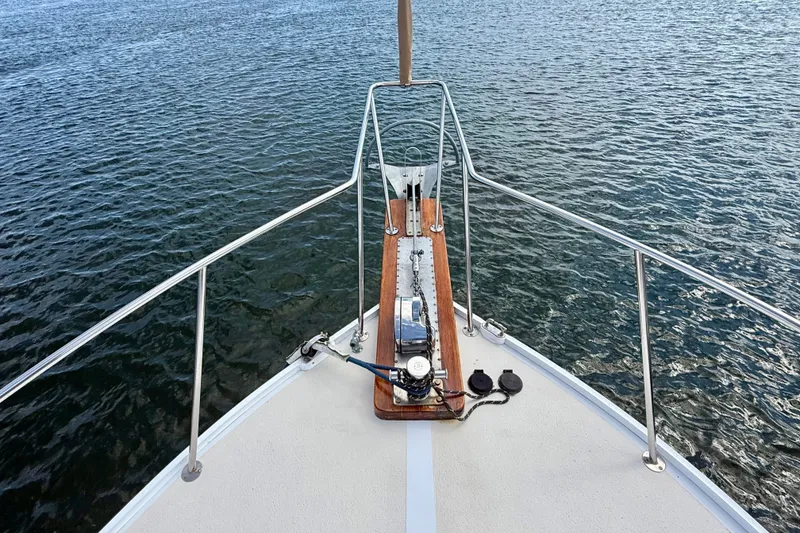 Slide: The Image of Bow view of 1987 Wilbur Flybridge Cruiser on calm water. - 24