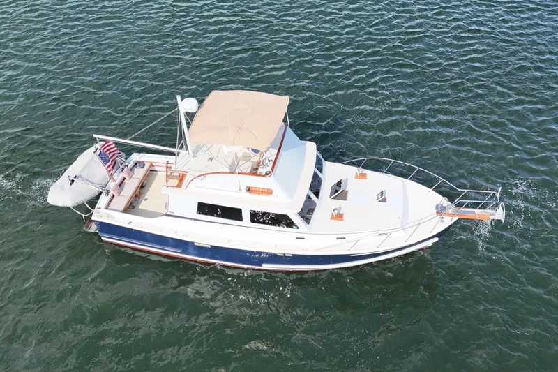 Slide: The Image of 1987 Wilbur Flybridge Cruiser on open water, aerial view, showcasing elegant design and craftsmanship. - 9