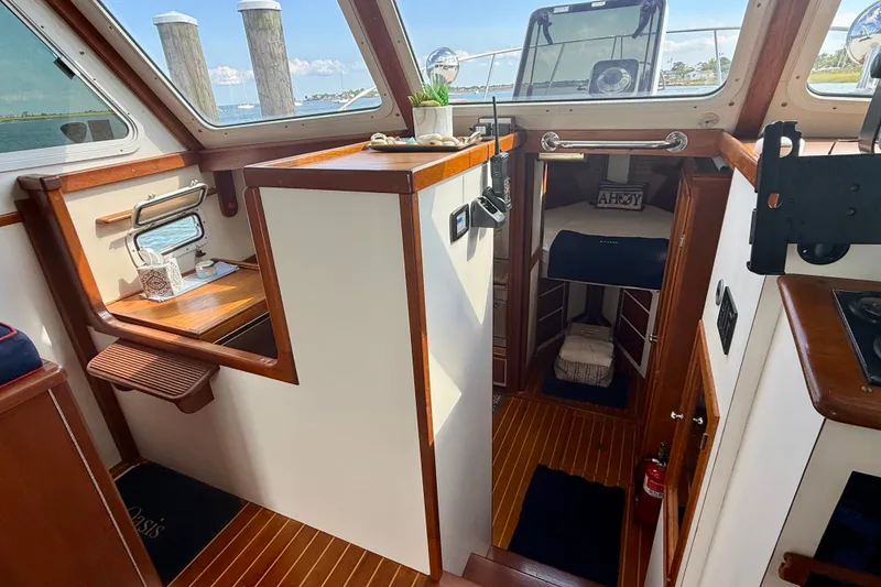 Slide: The Image of 1987 Wilbur Flybridge Cruiser interior with wood accents and nautical decor. - 47