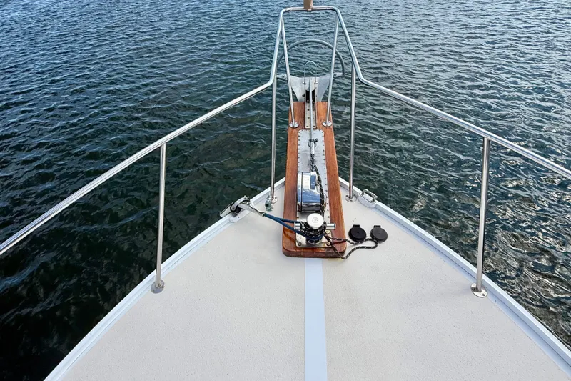 Slide: The Image of Bow of 1987 Wilbur Flybridge Cruiser with anchor and railing on calm water. - 23