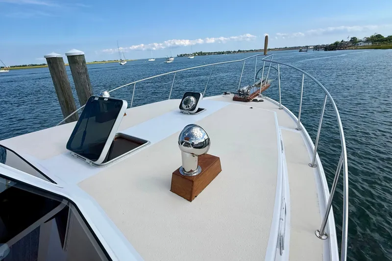 Slide: The Image of 1987 Wilbur Flybridge Cruiser on calm water, showcasing deck and railing. - 22