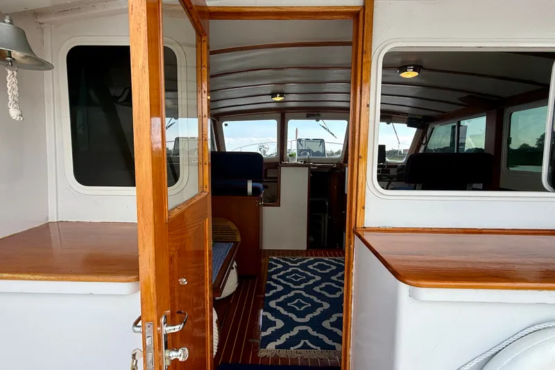 Slide: The Image of Interior view of a 1987 Wilbur Flybridge Cruiser with wooden accents and nautical decor. - 37