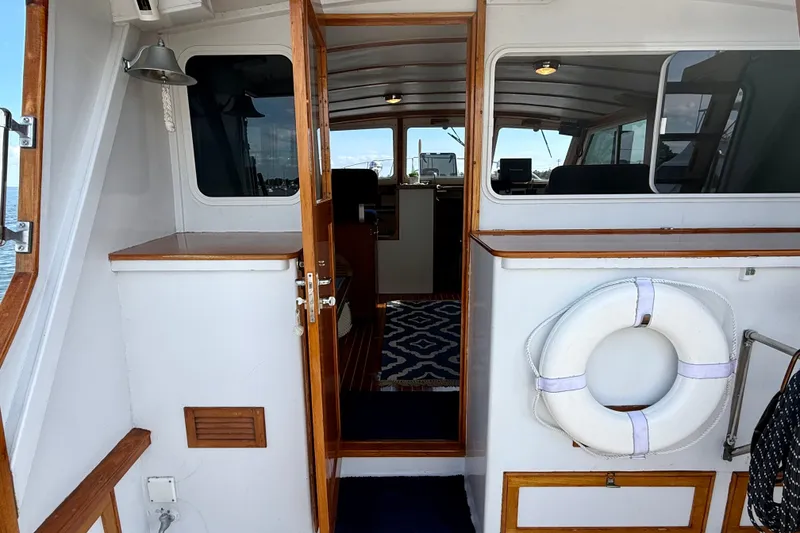 Slide: The Image of 1987 Wilbur Flybridge Cruiser interior with wooden accents and nautical decor. - 18