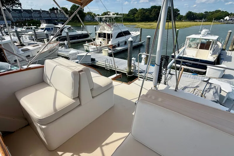 Slide: The Image of 1987 Wilbur Flybridge Cruiser docked at marina with comfortable seating and scenic view. - 33