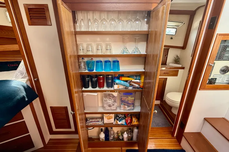 Slide: The Image of 1987 Wilbur Flybridge Cruiser interior with wooden cabinet and glassware. - 58