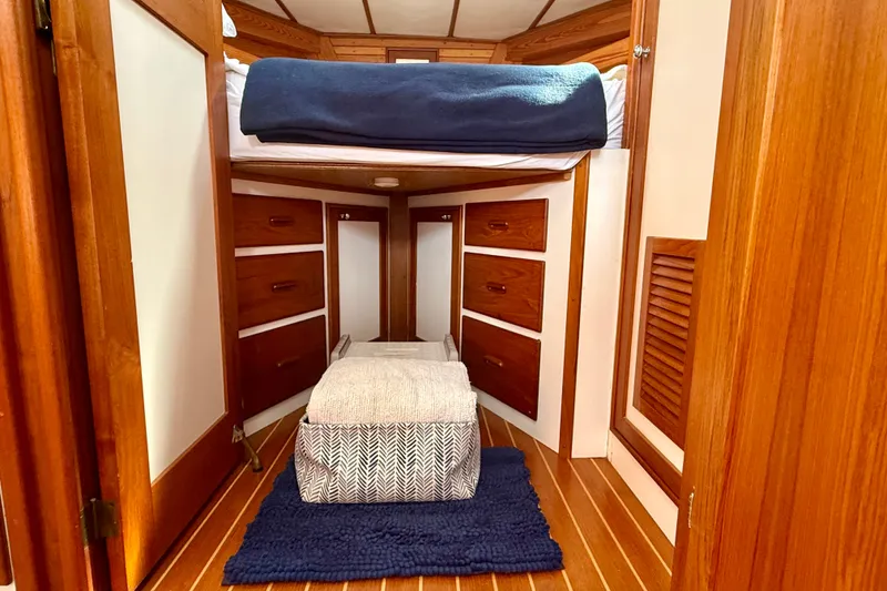 Slide: The Image of Cozy cabin interior of 1987 Wilbur Flybridge Cruiser with wooden drawers and bedding. - 54