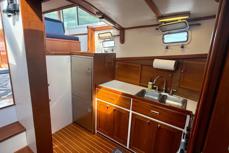 Slide: The Image of Interior of 1987 Wilbur Flybridge Cruiser with wooden cabinetry and stainless steel sink. - 49