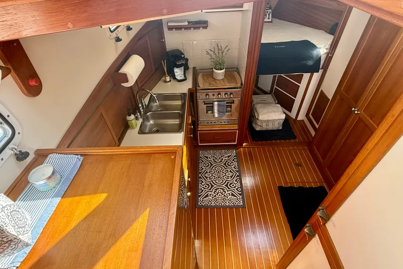 Slide: The Image of Interior of 1987 Wilbur Flybridge Cruiser with wood finishes and compact kitchen area. - 46
