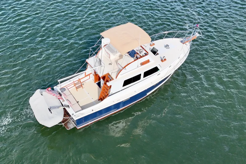 Slide: The Image of 1987 Wilbur Flybridge Cruiser on open water, aerial view. - 8