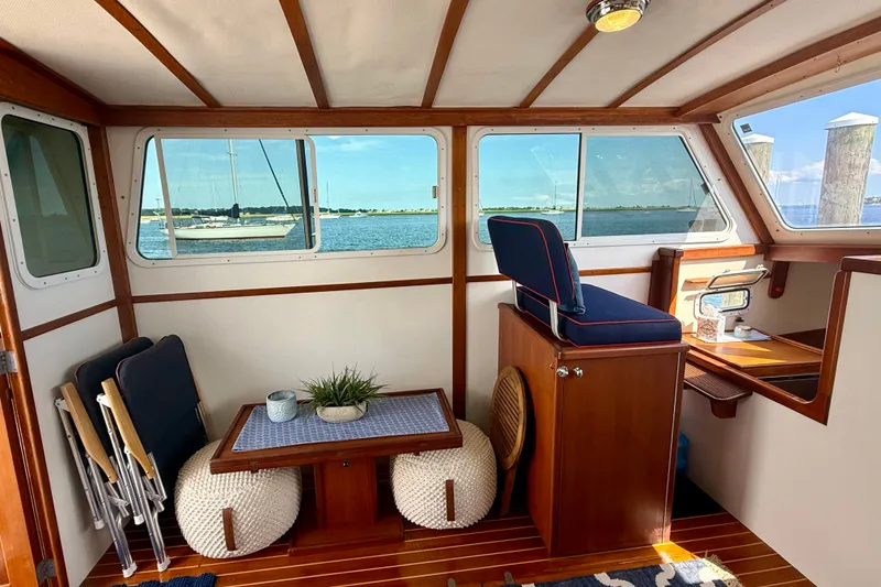 Slide: The Image of Interior of 1987 Wilbur Flybridge Cruiser with seating, table, and ocean view through windows. - 40