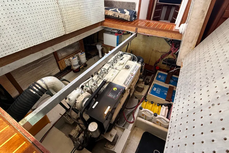 Slide: The Image of Engine room of a 1987 Wilbur Flybridge Cruiser, showcasing machinery and storage compartments. - 59