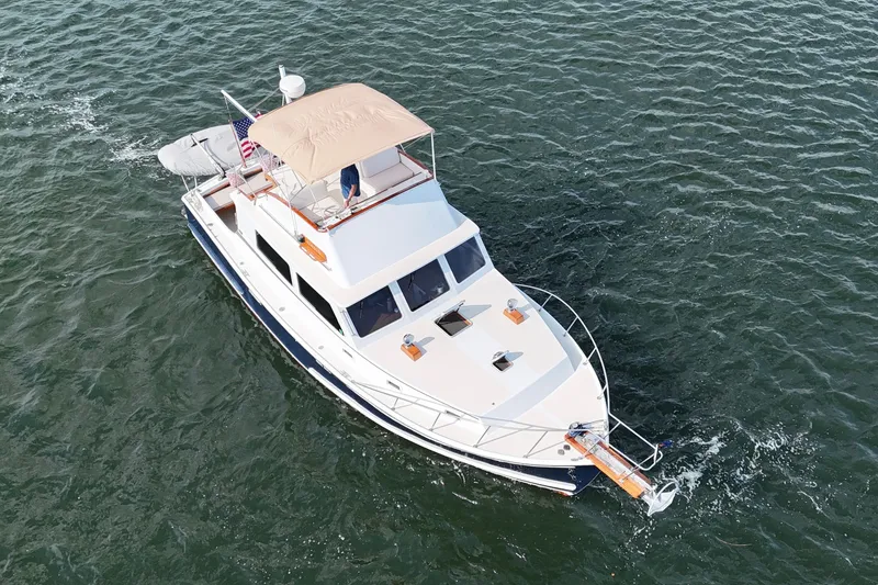 Slide: The Image of 1987 Wilbur Flybridge Cruiser navigating on open water, showcasing classic design and elegance. - 10