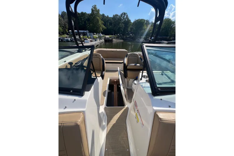 Slide: The Image of 2022 Sea Ray SPX 210 boat interior with seating, docked by a scenic lake. - 33