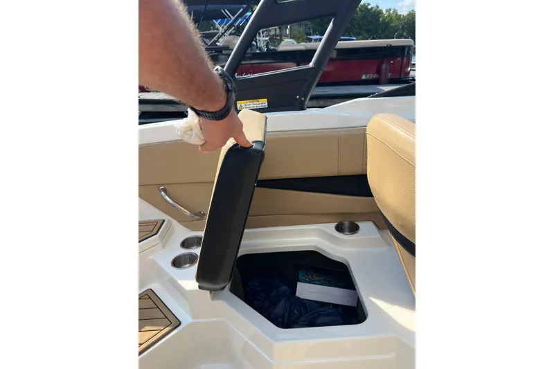 Slide: The Image of 2022 Sea Ray SPX 210 boat interior with storage compartment and cup holders. - 35