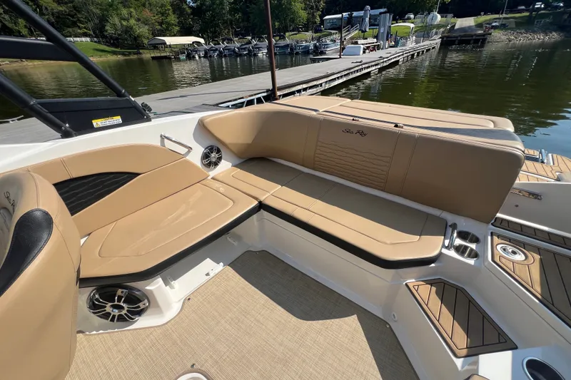 Slide: The Image of 2022 Sea Ray SPX 210 boat interior with tan seating and lake view. - 23