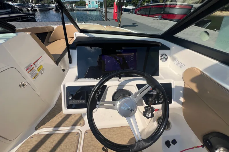 Slide: The Image of Interior view of 2022 Sea Ray SPX 210 boat cockpit with steering wheel and control panel. - 21