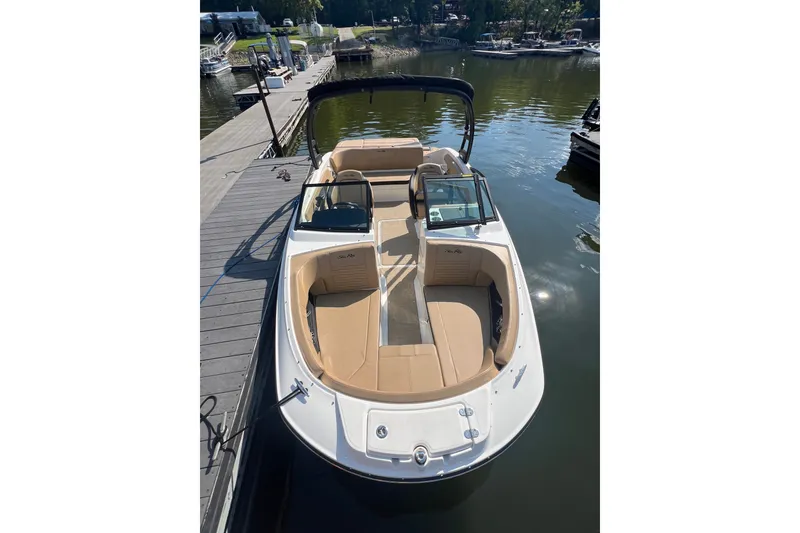 Slide: The Image of 2022 Sea Ray SPX 210 boat docked on calm water, featuring tan seating and sleek design. - 14