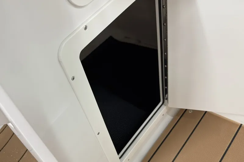 Slide: The Image of Open storage compartment on 2027 Chaparral 21 SSi boat, featuring sleek white interior. - 24