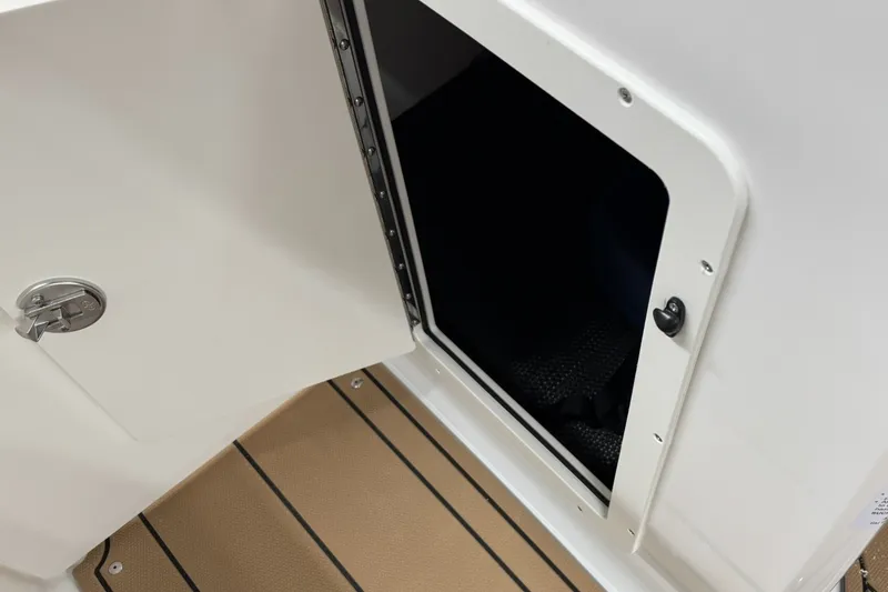 Slide: The Image of Open storage compartment on 2027 Chaparral 21 SSi boat with teak flooring. - 23