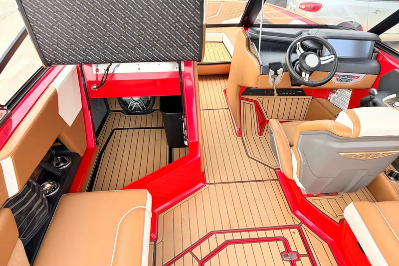 Slide: The Image of 2022 Nautique Super Air Nautique G25 interior with tan seats and red accents. - 22